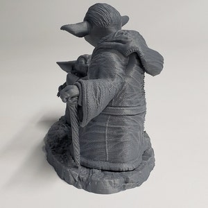 Peut inclure: Une figurine en plastique gris imprim&eacute;e en 3D du personnage de Star Wars, Yoda, tenant un b&acirc;ton de marche. Yoda porte une robe et a une petite figurine verte de Baby Yoda assise sur ses genoux.