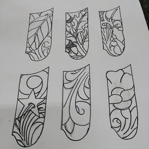Può includere: Sei disegni in bianco e nero di diversi design su uno sfondo bianco. I design sono tutti a forma di un rettangolo lungo e stretto con angoli arrotondati. I design includono una foglia, una stella e vari vortici.