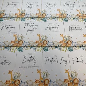 May include: A selection of white cards with text such as "Adoption Journey," "Training," and "Stage One." Each card has a watercolour illustration of safari animals and foliage. The cards are designed for adoption milestones.