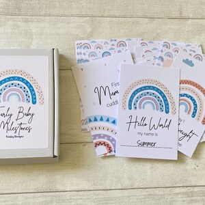 May include: A set of colorful rainbow baby milestone cards with a rainbow design and the text "Early Baby Milestones" on the box. The cards feature different milestones such as "First Mum Cuddle", "Hello World", and "First Night".