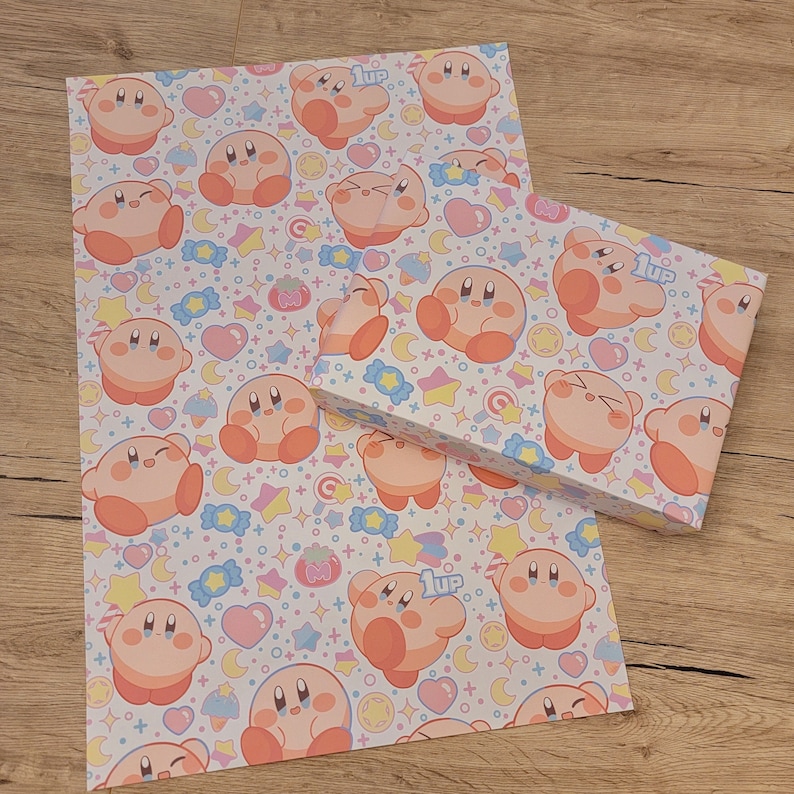 May include: Pink and white wrapping paper with a repeating pattern of a pink cartoon character with a 1up mushroom on its head. The character is surrounded by stars, hearts, and candy.