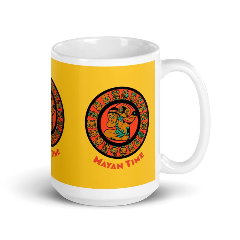 May include: White ceramic mug with a yellow background and a colorful Mayan calendar design. The design features a red circle with a turquoise and orange figure in the center. The text "MAYAN TIME" is printed below the circle.