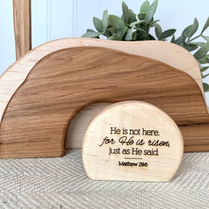 May include: Wooden Easter tomb with a cross and a sign that reads "He is not here, for He is risen, just as He said. Matthew 28:6"