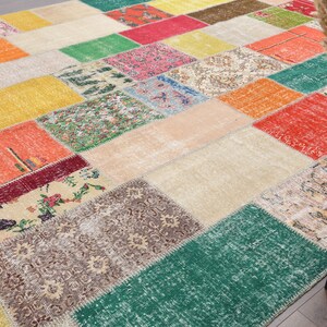 K&ouml;nnte beinhalten: Ein farbenfroher Patchwork-Teppich mit einer Vielzahl von geometrischen Formen und Mustern. Der Teppich weist eine Mischung aus Farben auf, darunter Rot, Gr&uuml;n, Gelb, Orange und Beige. Der Teppich besteht aus mehreren zusammengen&auml;hten Stoffst&uuml;cken.