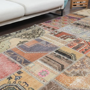 May include: A patchwork rug with a variety of colors and patterns, including brown, beige, red, and blue. The rug is made of different pieces of fabric that have been sewn together.