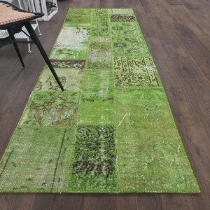 Może przedstawiać: Zielony i brązowy dywanik w stylu patchwork z efektem zużycia. Dywanik jest wykonany z różnych kawałków tkaniny zszytych ze sobą.