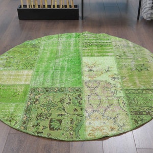 Könnte beinhalten: Ein runder grüner Patchwork-Teppich mit verschiedenen Mustern und Texturen. Der Teppich ist aus recycelten Materialien hergestellt und hat einen Used-Look.