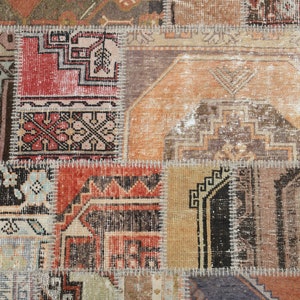 May include: A patchwork rug made of different pieces of fabric with intricate patterns in shades of brown, beige, red, and blue. The rug has a worn and vintage look.