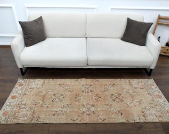 Puede incluir: Un tapete corredor beige claro con un patrón floral. El tapete tiene un aspecto desgastado y está hecho de un material suave y tejido.