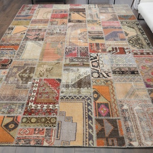 May include: A patchwork rug with a variety of colors and patterns, including red, orange, brown, and beige. The rug is made up of many different pieces of fabric that have been sewn together.