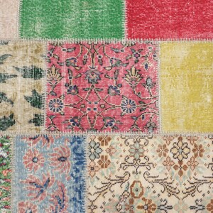 K&ouml;nnte beinhalten: Ein mehrfarbiger Patchwork-Teppich mit einem Used-Look. Der Teppich besteht aus rechteckigen Flicken in verschiedenen Farben, darunter Rot, Gr&uuml;n und Gelb. Einige Flicken weisen florale Designs auf, w&auml;hrend andere geometrische Muster haben. Der Teppich hat eine Vintage-&Auml;sthetik.