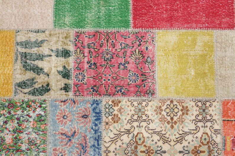 K&ouml;nnte beinhalten: Ein mehrfarbiger Patchwork-Teppich mit einem Used-Look. Der Teppich besteht aus rechteckigen Flicken in verschiedenen Farben, darunter Rot, Gr&uuml;n und Gelb. Einige Flicken weisen florale Designs auf, w&auml;hrend andere geometrische Muster haben. Der Teppich hat eine Vintage-&Auml;sthetik.
