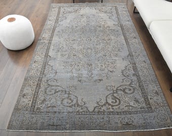 May include: A vintage rug with a faded blue background and a brown floral pattern. The rug has a distressed look and is perfect for adding a touch of bohemian style to any room.