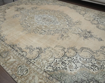 Puede incluir: Una alfombra rectangular grande con un intrincado diseño floral en beige, crema y negro. La alfombra presenta un diseño de medallón central y un borde detallado, creando una estética vintage. Adecuada para salones y dormitorios.