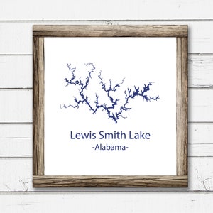 May include: A framed print of a map of Lewis Smith Lake in Alabama. The lake is outlined in blue and the text "Lewis Smith Lake -Alabama- " is printed below the map.