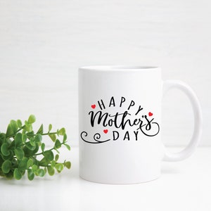 May include: White ceramic coffee mug with a black cursive inscription that reads "Happy Mother's Day" with small red hearts surrounding the text.