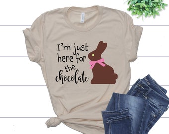 May include: A beige t-shirt with a chocolate bunny graphic and the text "I'm just here for the chocolate".