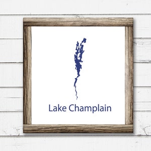 May include: A framed print of a blue outline of Lake Champlain with the text "Lake Champlain" below the outline.