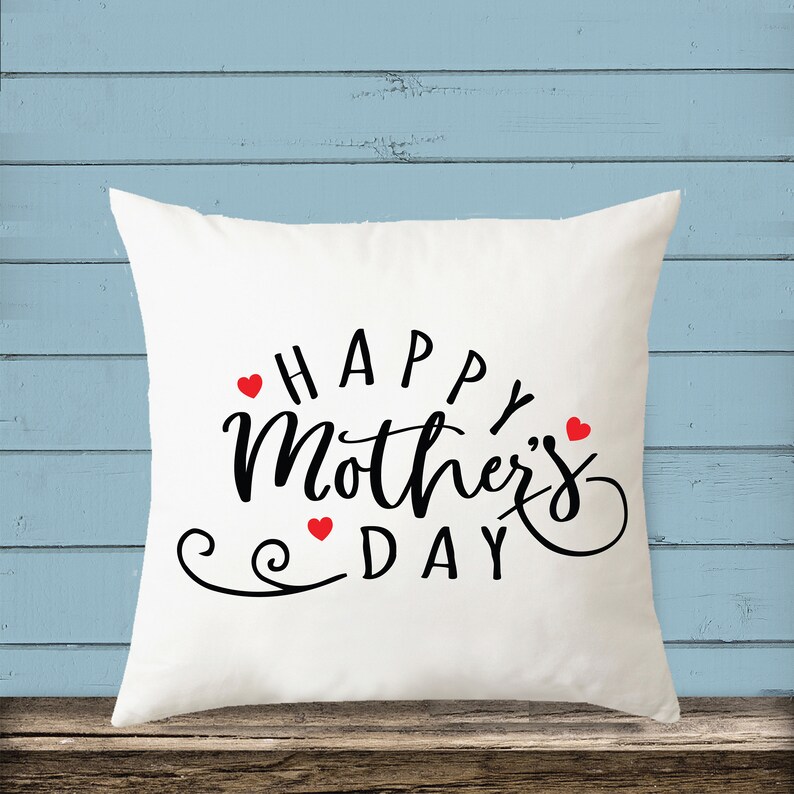 May include: White throw pillow with the text "Happy Mother's Day" in black script lettering and three red hearts.