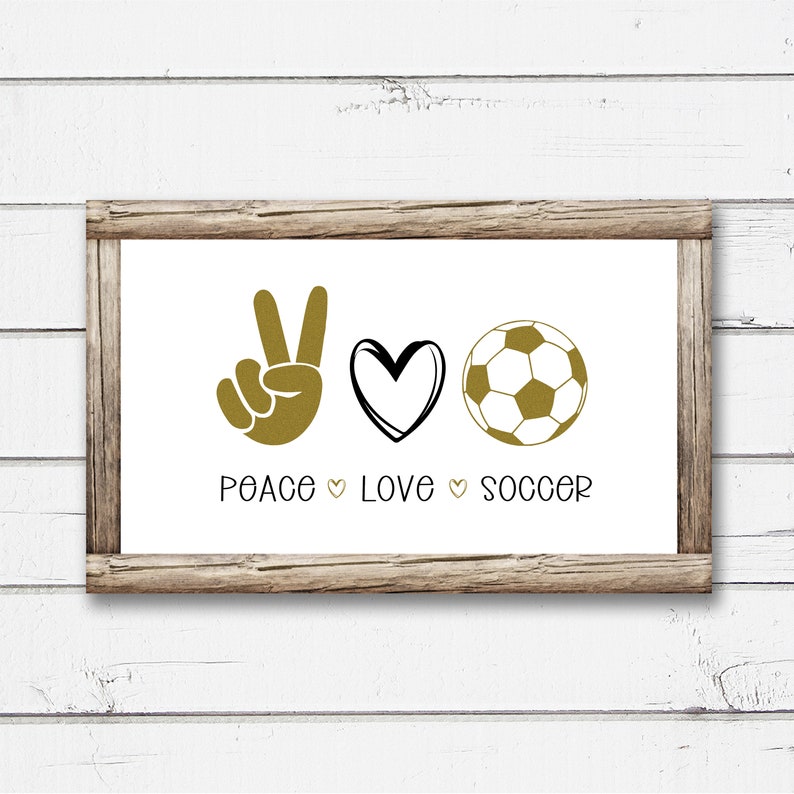 May include: A framed print with the text "Peace Love Soccer" in black lettering. The print features a gold peace sign, a gold heart, and a gold soccer ball.