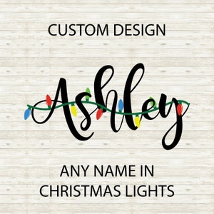 Puede incluir: Un diseño personalizado con el nombre "Ashley" escrito en letra cursiva con una cadena de luces navideñas de colores envueltas alrededor de las letras. El texto "ANY NAME IN CHRISTMAS LIGHTS" está debajo del nombre.
