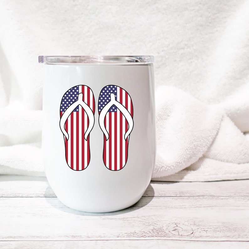 May include: White stainless steel tumbler with a red, white, and blue American flag design on a pair of flip flops.