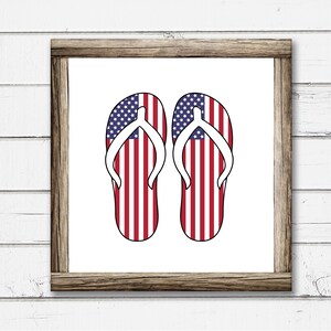May include: A pair of flip flops with the American flag design. The flip flops are white with red and blue stripes.