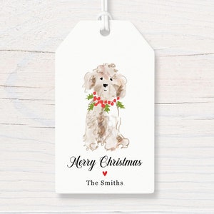 May include: White Christmas gift tag with a watercolor illustration of a white dog wearing a red berry garland. The tag says "Merry Christmas" and "The Smiths".