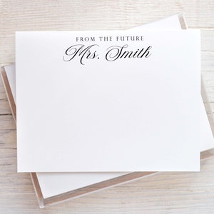 May include: White stationery cards with a black cursive inscription that reads "From the Future Mrs. Smith".
