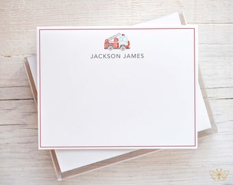 May include: A stack of white note cards with a red border. The top card features a watercolor illustration of a red fire truck with a ladder. The text "JACKSON JAMES" is printed below the illustration.