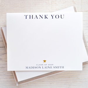 May include: White thank you note card with blue text that says "Thank You". Below the text is a gold graduation cap icon and the text "Class of 2023" and "MADISON LAINE SMITH".
