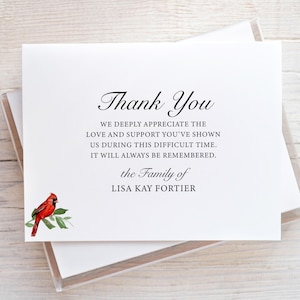 May include: A white thank you card with black text that reads "Thank You" and "We deeply appreciate the love and support you've shown us during this difficult time. It will always be remembered. The Family of Lisa Kay Fortier". A red cardinal with a green leaf branch is in the bottom left corner.