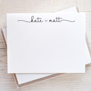 May include: A white card with the text "kate ♥ matt" written in black cursive script. The card is in a clear plastic holder.