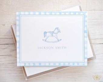 May include: Blue and white gingham stationery with a rocking horse illustration and the name "JACKSON SMITH" printed in blue.