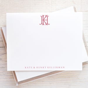 May include: A white card with a pink monogram of the letters "KH" and the text "KATE & HENRY KELLERMAN" printed below.