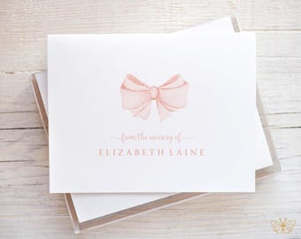 May include: A set of pink and white stationery cards with a watercolor bow and the text "from the nursery of ELIZABETH LAINE".