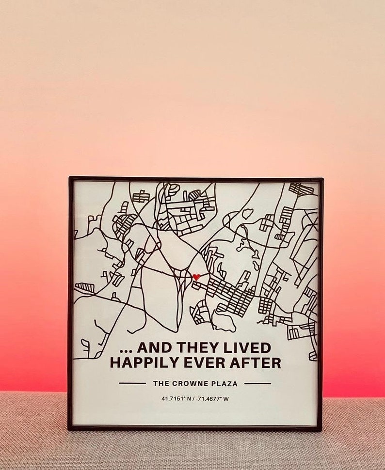 May include: A black and white map of a city with a red heart marking a location. The text below the map reads "... AND THEY LIVED HAPPILY EVER AFTER THE CROWNE PLAZA 41.7151* N/-71.4677" W