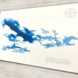 Op de afbeelding: Een blauwe en witte topografische kaart van Lake Lauzon in Algoma Mills, Ontario. De kaart toont de diepte van het meer met contouren. De co&ouml;rdinaten van het meer zijn 46&deg;11'55.1"N 82&deg;50'10.8"W.