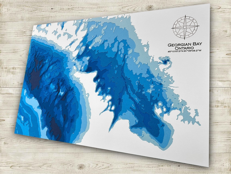 Puede incluir: Un mapa topogr&aacute;fico azul y blanco de la Bah&iacute;a Georgiana, Ontario. El mapa muestra la profundidad del agua en tonos de azul. Las coordenadas 44.91073&deg;N 81.3608.2&deg;W est&aacute;n impresas en la esquina inferior derecha.