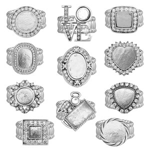 May include: Ten silver-toned rings with clear rhinestones. The rings feature different shapes, including round, oval, square, heart, and a ring with the word "LOVE" on it.