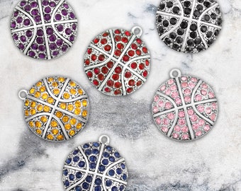 May include: Six silver basketball charms with different colored rhinestones. The charms are purple, red, yellow, pink, blue, and black.