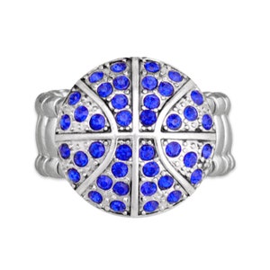 May include: A silver ring with a blue rhinestone basketball design.