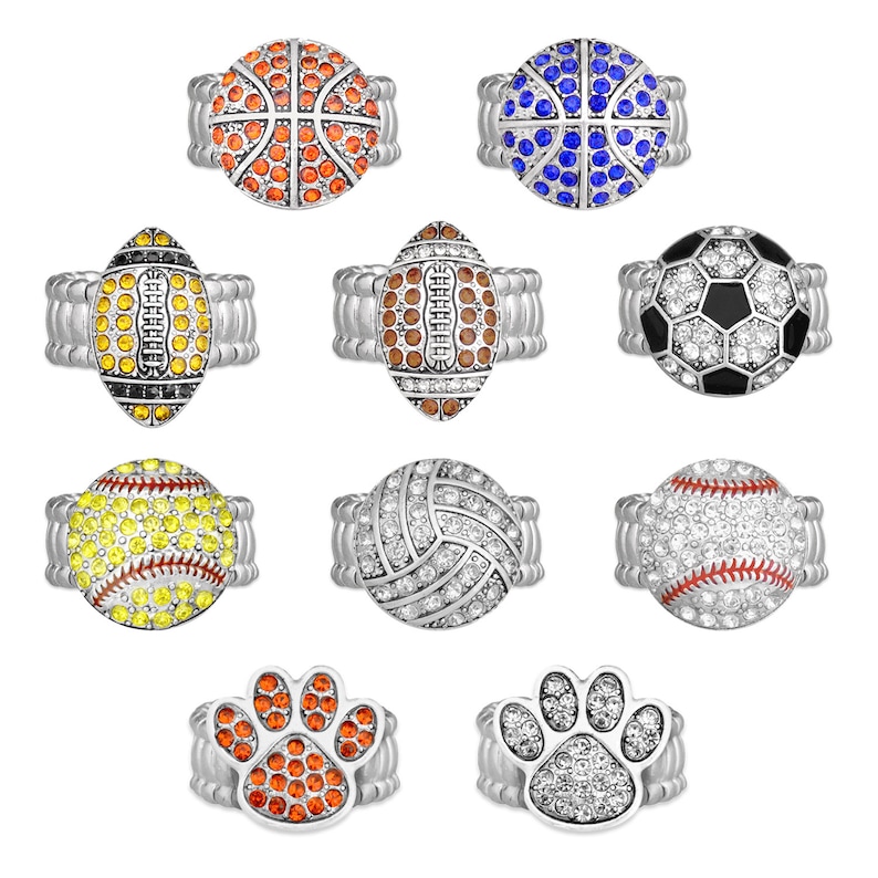 May include: Set of ten silver rings with different sports-themed designs. The rings feature a basketball, football, soccer ball, baseball, volleyball, and paw print. Each ring is adorned with colorful rhinestones.