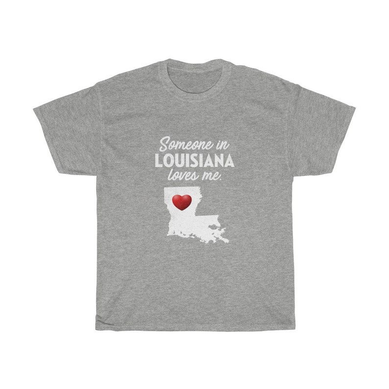 May include: Gray t-shirt with the text "Someone in LOUISIANA loves me." and a red heart over an outline of the state of Louisiana.