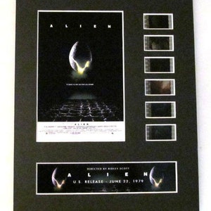 May include: A black and white movie poster for the film "Alien" with a black and white film strip featuring scenes from the movie. The poster features the text "Alien" and the tagline "In space, no one can hear you scream." The film strip is in a black frame. The poster also includes the text "Directed by Ridley Scott" and "U.S. Release - June 22, 1979."