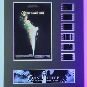 May include: A framed movie poster and film strip for the movie Constantine starring Keanu Reeves. The poster features a dark image of Keanu Reeves as John Constantine with the title of the movie in white text. The film strip has five frames showing scenes from the movie. The poster is dated February 18.