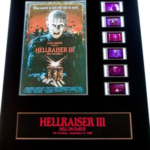 May include: A framed movie poster for Hellraiser III: Hell on Earth, featuring a character with a hooked, metal face and a box in their hand. The poster is surrounded by six film cell frames.