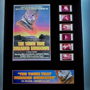 May include: A movie poster for the film "The Town That Dreaded Sundown". The poster features a masked figure in a dark hooded robe against a sunset background. The text on the poster reads "In 1946 this man killed five people... Today he still lurks the streets of Texarkana, Ark." and "The Town That Dreaded Sundown".