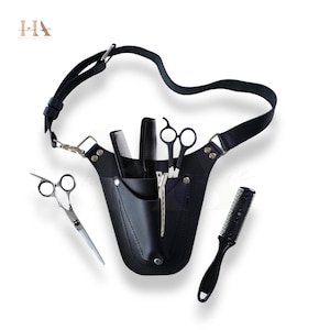 May include: Black leather barber tool belt with a shoulder strap, holding combs, scissors, and a hair clipper. The belt has a pocket for tools and a silver clasp. The tools are arranged on a white background.