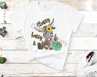 May include: White t-shirt with a gray donkey wearing a sunflower crown. The text "Classy Sassy & a bit" is printed on the shirt.
